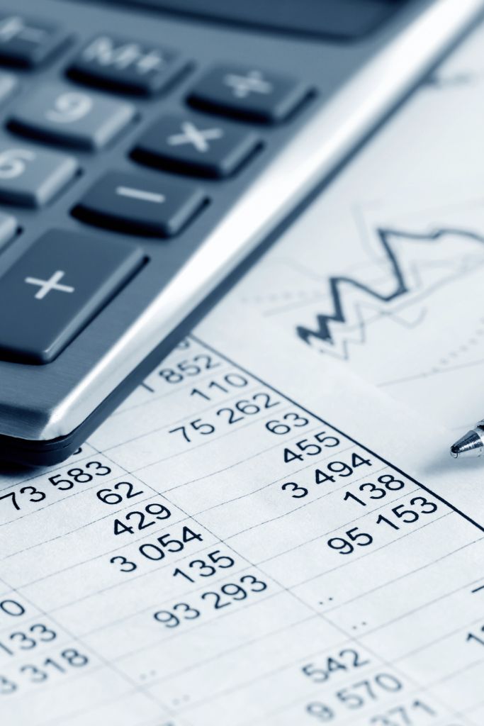 A calculator placed next to a ledger on a desk, highlighting traditional accounting tools enhanced by IT solutions.